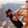 Man hanging from a cliff free soloing