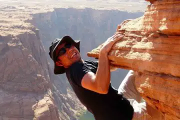 Man hanging from a cliff free soloing