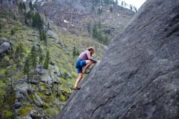 A climber using his climbing shoes to climb a wall