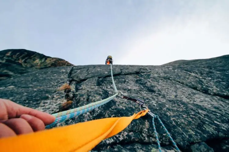Climber belaying his partner on a rock face