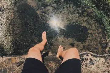 A man climbing a mountain barefoot