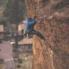 Tall man climbing rock wall