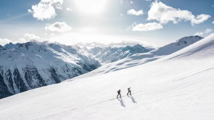Two men climbing a snow-covered mountain